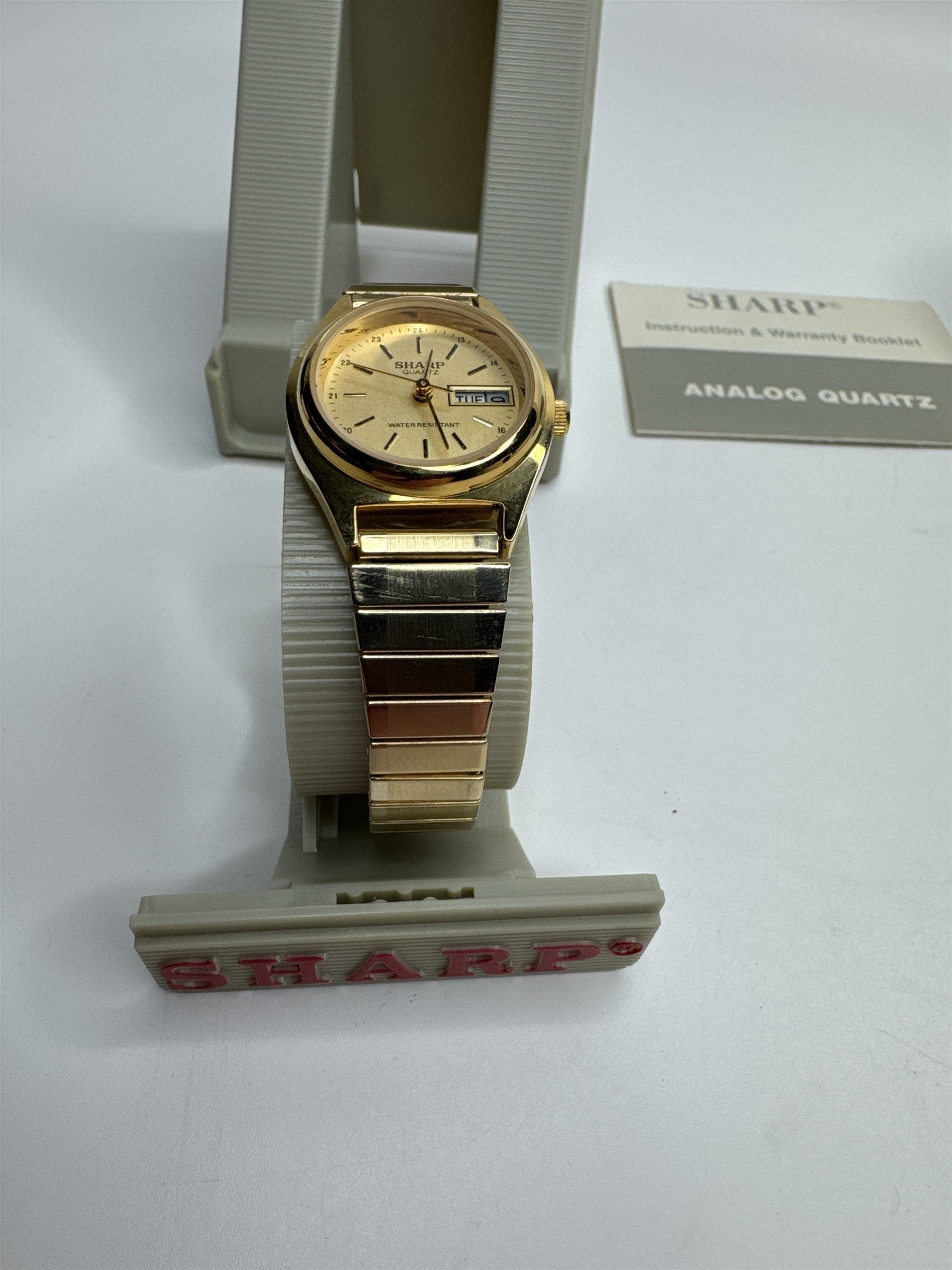 Vintage Sharp Gold Toned Mens Stretch Metal Band Calendar Watch Water Resistant