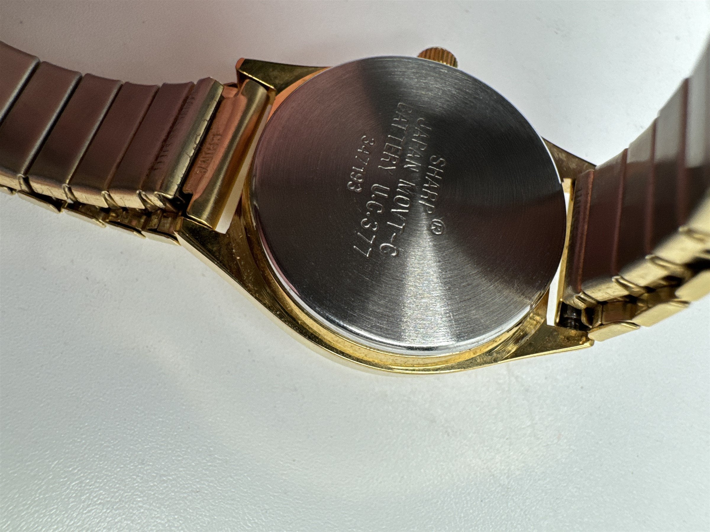Vintage Sharp Gold Toned Mens Stretch Metal Band Calendar Watch Water Resistant